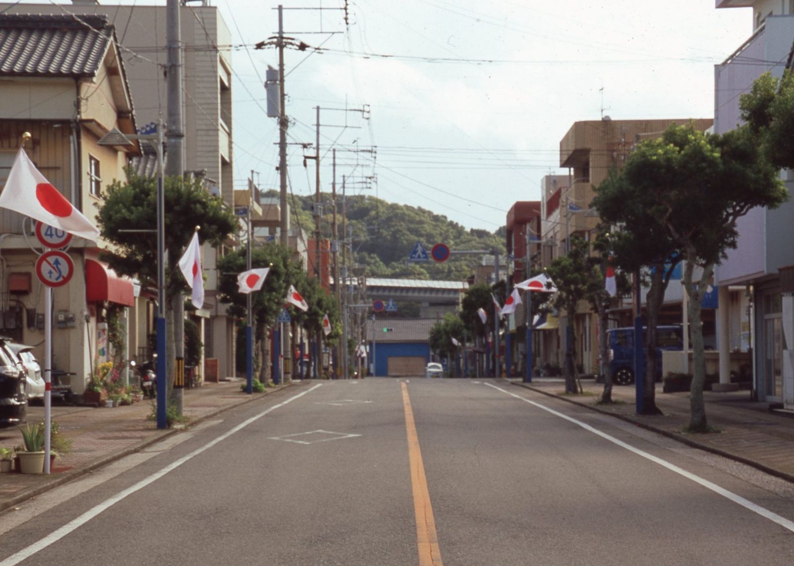 日の丸の旗が並ぶ、山へ向かう通り