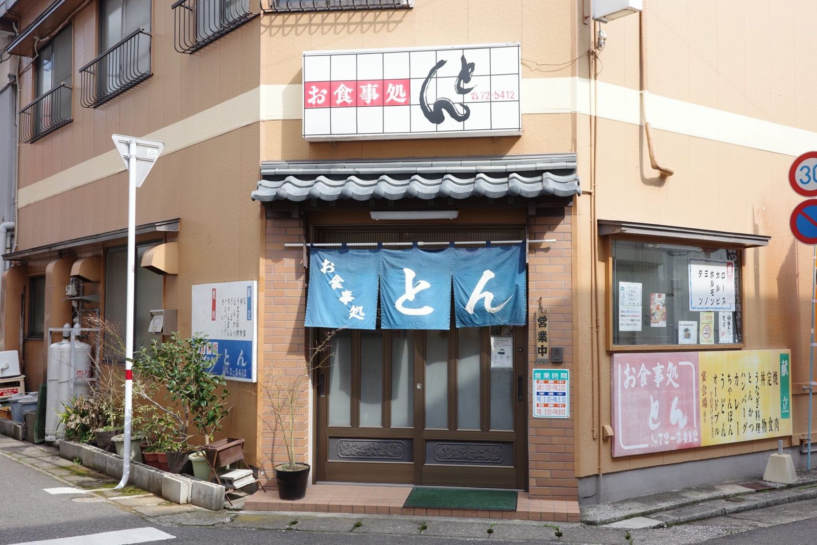 「お食事処 とん」の看板と藍色ののれん